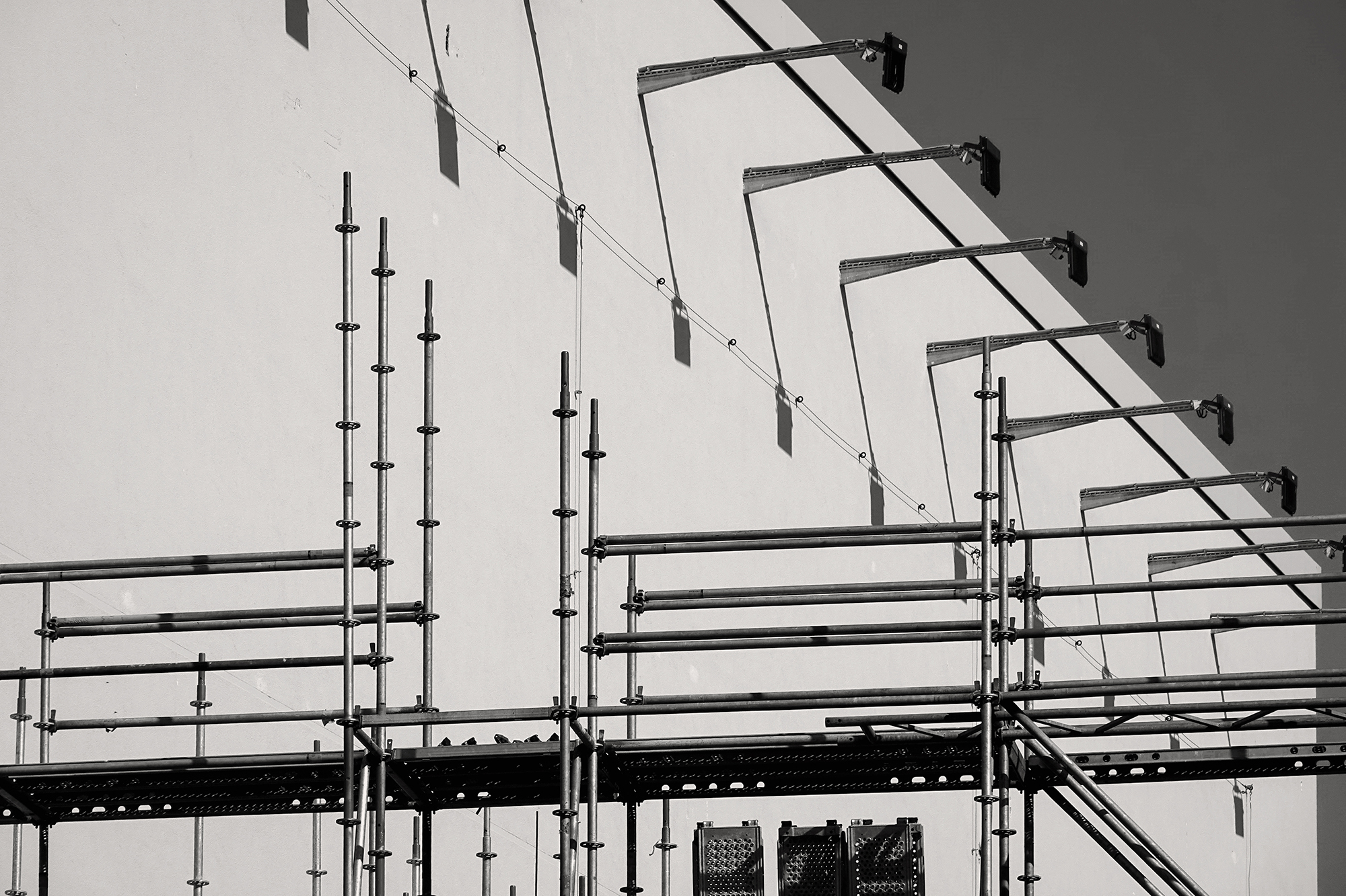 Christoph Radke, Berlin, eine Wand der East Side Mall mit Lampen und einem Bauzaun davor, 2021